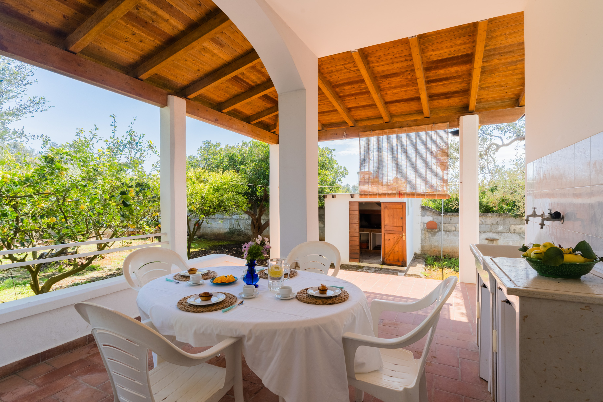 Veranda coperta attrezzata per mangiare all'aperto presso Villa Li Giannelli.