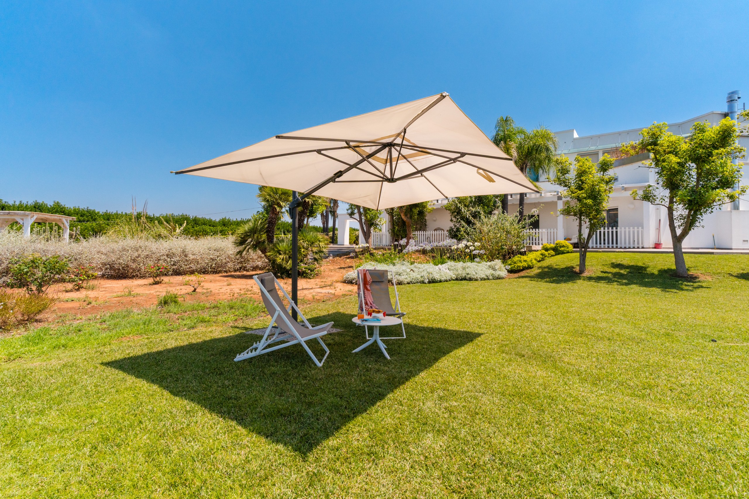 ombrellone e sedie in giardino con tavolino attico villa cucci